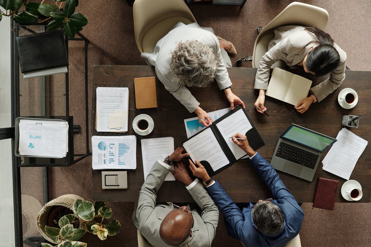 Diverse business team collaborating on digital marketing strategy around a laptop
