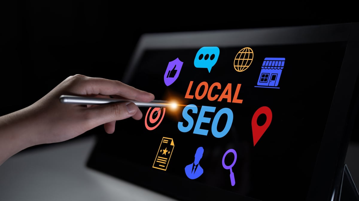 A hand using a stylus interacts with a screen displaying colorful local SEO related icons. This image conveys modern digital marketing strategies vital for business growth. Gantry