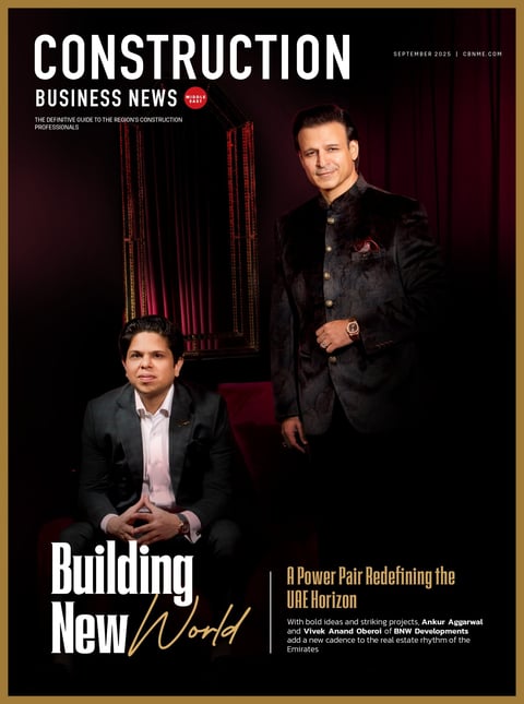 Construction Business News magazine cover featuring two men in business suits against a dark background with red steel structural elements